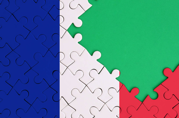 Frankreich-Flagge ist auf einem fertigen Puzzle mit freiem grünen Kopierraum auf der rechten Seite abgebildet. - Foto, Bild