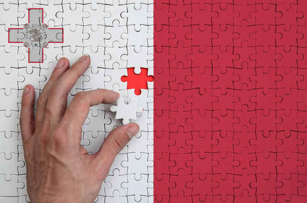 Malta bayrağı yukarı doğru elini tamamlar bir bulmaca, tasvir. - Fotoğraf, Görsel