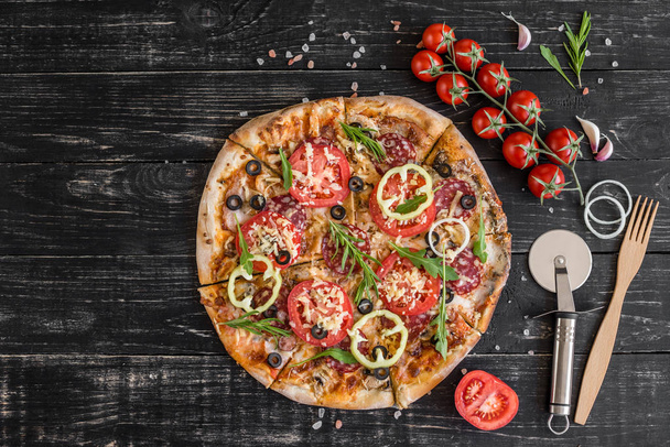 Pizza de verduras, champiñones y tomates sobre fondo de madera negra. Se puede utilizar como fondo
 - Foto, imagen