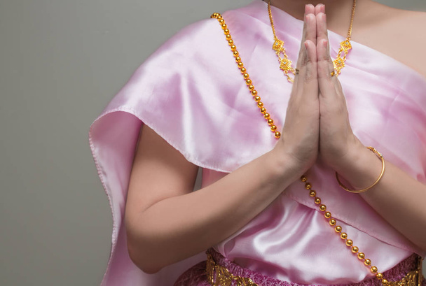 Hermosa chica tailandesa en traje de vestir tradicional, presione las manos juntas en el pecho
 - Foto, imagen