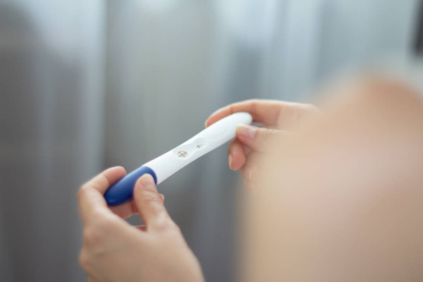 Mladá žena s těhotenský test v ruce pozitivní výsledek - Fotografie, Obrázek