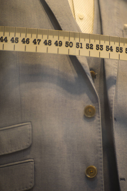 Räätäli näyteikkuna mittatilaustyönä räätälöity puku myymälä mallinukke muodollinen paita ja solmio mittanauhalla
. - Valokuva, kuva
