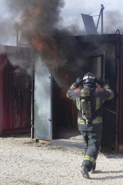 İtfaiyeci yangın söndürme istasyonunu söndürüyor. Acil durum güvenlik tatbikatı prosedürü.. - Fotoğraf, Görsel