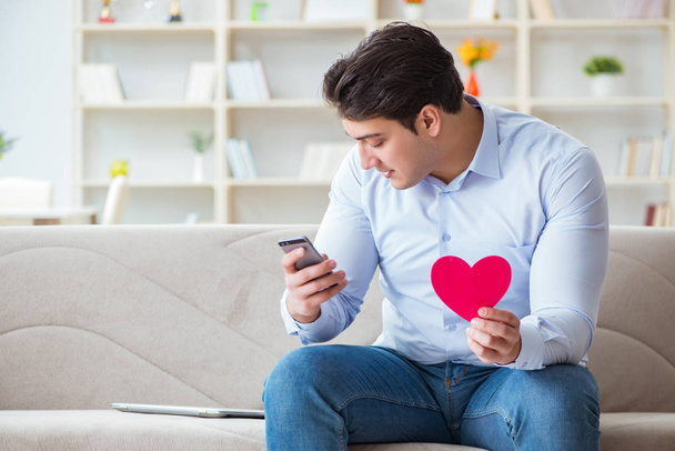 Молодой человек болтает со своей возлюбленной по мобильному телефону - Фото, изображение