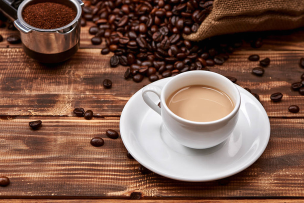 木製テーブルの上のコーヒー豆とコーヒー カフェラテ. - 写真・画像
