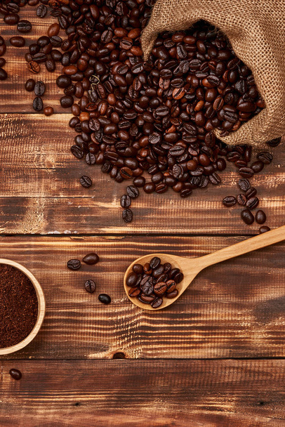 Kávová zrna v lžíci a šálek horkého nápoje - Fotografie, Obrázek