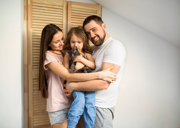 happy family at home in her room celebrating the fourth birthday of her daughter, present cat - Фото, зображення
