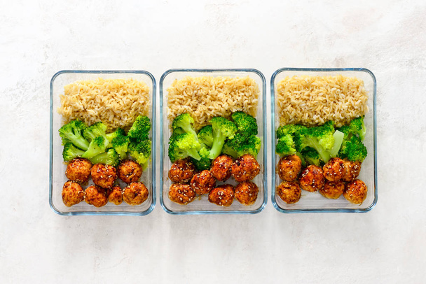 Estilo asiático salsa teriyaki pollo bolas de carne con brócoli y arroz preparado y poner en una comida para llevar cajas, vista desde arriba
 - Foto, Imagen