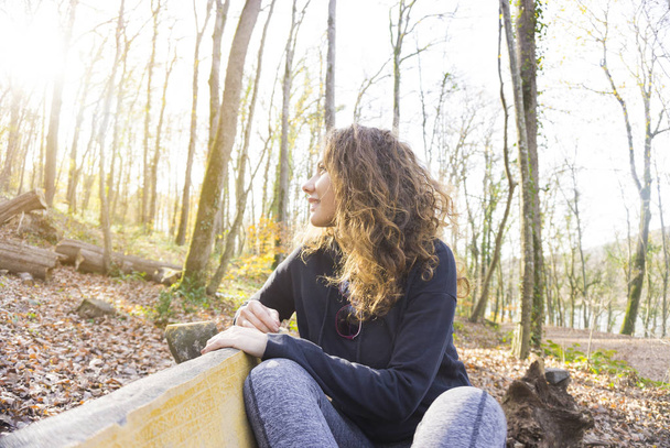 Beautiful young woman on the nature bench. - Fotó, kép