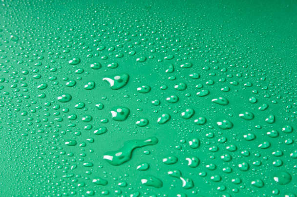 Gotas de agua, diferentes tamaños sobre un fondo verde
 - Foto, Imagen