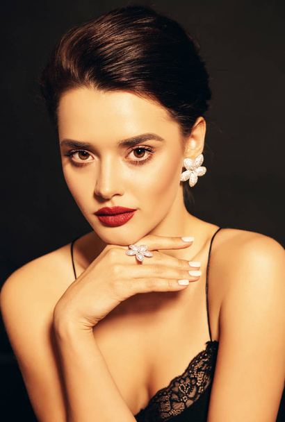 fashion studio photo of beautiful young woman with dark hair and perfect glowing skin, in elegant dress and jewelry - Photo, Image