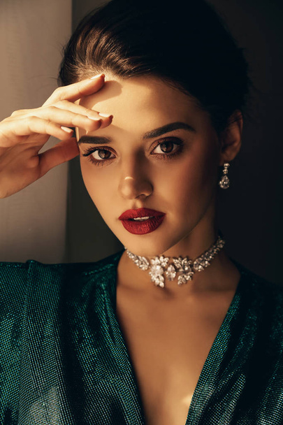 fashion studio photo of beautiful young woman with dark hair and perfect glowing skin, in elegant dress and jewelry - Фото, зображення