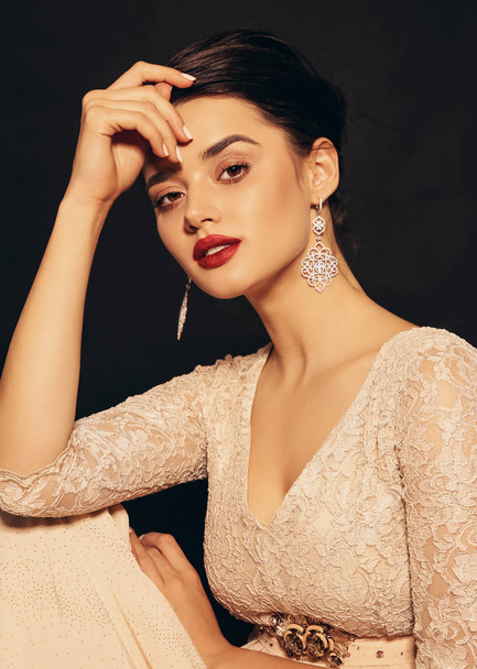 fashion studio photo of beautiful young woman with dark hair and perfect glowing skin, in elegant dress and jewelry - Foto, afbeelding