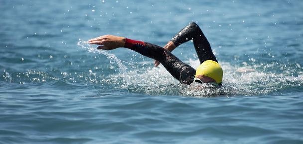 триатлону довгострокове плавання, люди в гідрокостюмі плавають на тріатлоні
 - Фото, зображення
