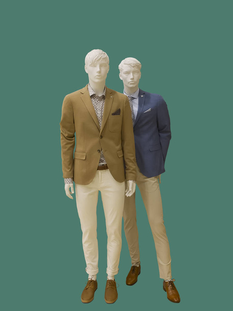 Dos maniquíes masculinos de cuerpo entero vestidos con ropa casual, aislados sobre fondo verde. No hay marcas u objetos de copyright. - Foto, Imagen