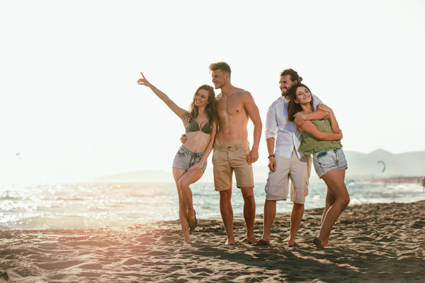 Группа молодых друзей отдыхает и веселится на песчаном пляже
 - Фото, изображение