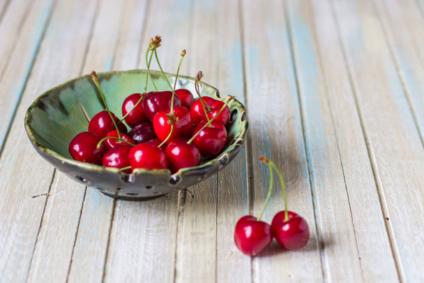 Cerejas em uma chapa em uma mesa de madeira. Cereja vermelha fresca
. - Foto, Imagem