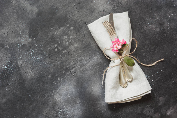 Spring festive table setting with cutlery and lilac flower on black stone table. Copy space. Flat lay. - Foto, imagen