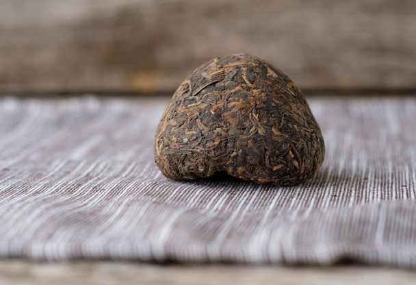 Китайский старый чай Shen Puer в виде гнезда на столе
 - Фото, изображение