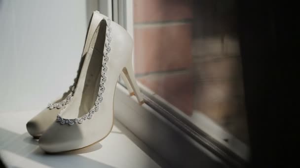 Λευκά παπούτσια στο περίπτερο στιλέτο στο παράθυρο - Πλάνα, βίντεο