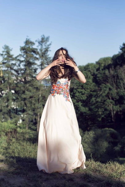 Meisje in een lange jurk, wandelen in de botanische tuin - Foto, afbeelding