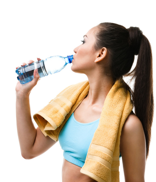 Athletic woman drinks water from the bottle - Fotó, kép