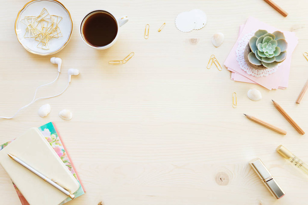 Жіночий Домашній офіс стіл таблиці в пастельних тонах. Робоча область з зошити, чашку кава і прикрас на світлому фоні дерев'яні з копією простір. Плоскі мирян, top погляд - Фото, зображення