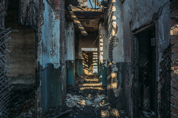 Ruins of burned brick house after fire disaster accident. Corridor inside, building without roof, heaps of ashes - Photo, Image