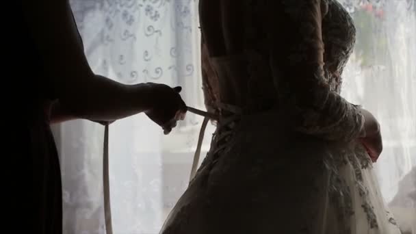 Mężczyzna wiązanie gorsetu na narzeczonych, suknia ślubna - Materiał filmowy, wideo