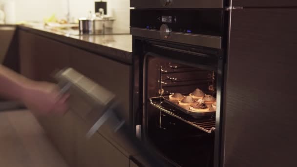 Womans hand opens oven, takes burnt cookies, smoke from overcooked food coming - Footage, Video