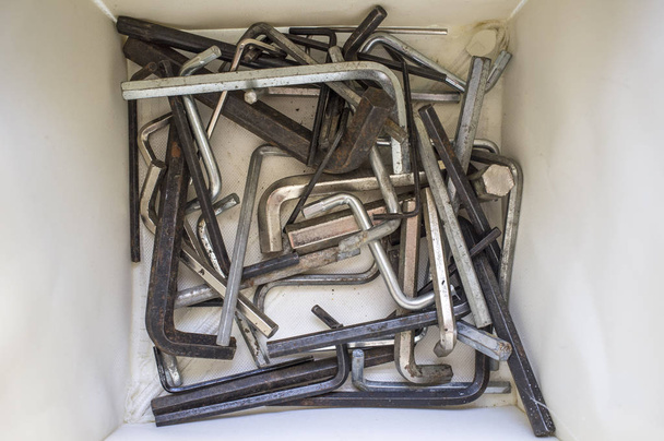 Box full of used hex keys for end-user assembly furniture. Closeup  - Photo, Image