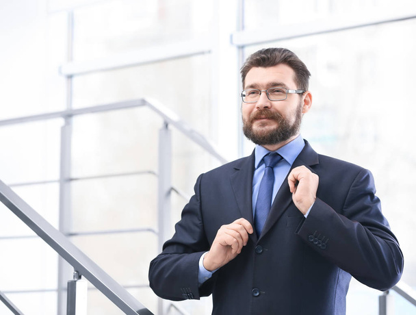 Portrait of confident mature man in elegant suit on stairs - Foto, Imagen