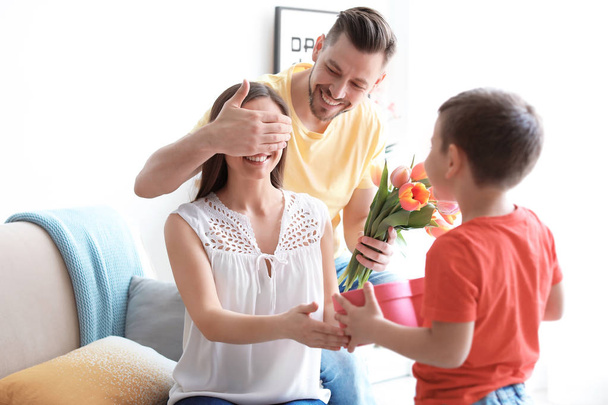 Happy woman receiving gifts from her husband and son at home. Mother's day celebration - Fotoğraf, Görsel