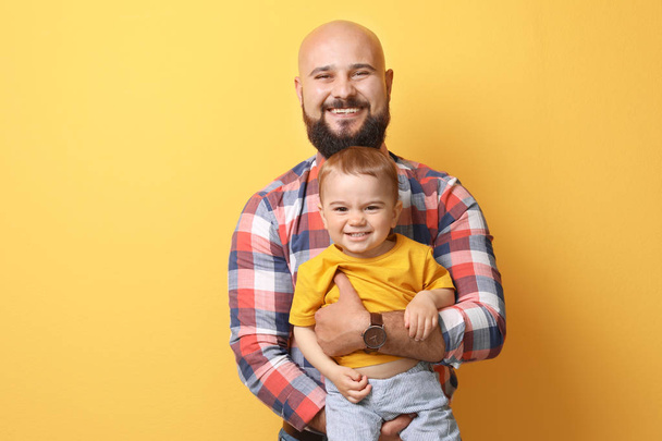 Portrait of dad and his little son on color background - Fotoğraf, Görsel