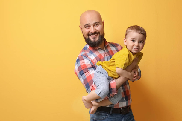 Portrait of dad and his little son on color background - Foto, Imagem