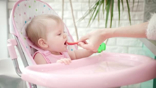 Édes kislány, aki zöldséget eszik. Anyai kéz etetés gyermek piros paprika - Felvétel, videó