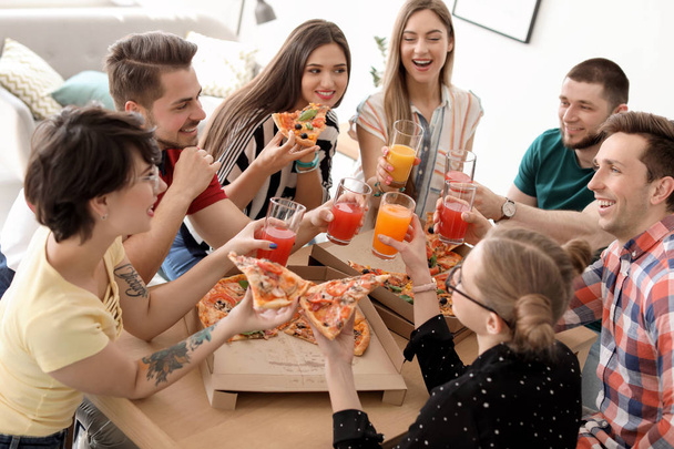 Молоді люди весело проводять вечірку з смачною піцою в приміщенні
 - Фото, зображення