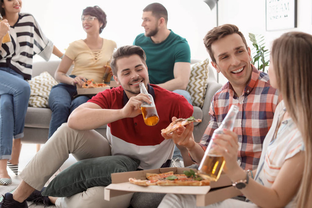 Young people having fun party with delicious pizza indoors - Fotó, kép