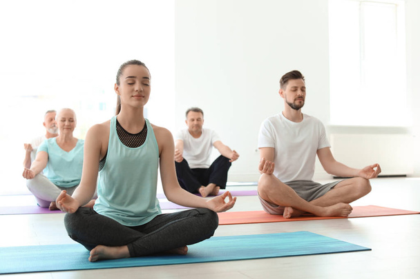 Group of people in sportswear practicing yoga indoors - Foto, immagini