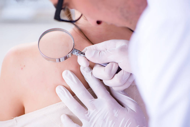 Médico examinando la piel de una paciente femenina - Foto, imagen