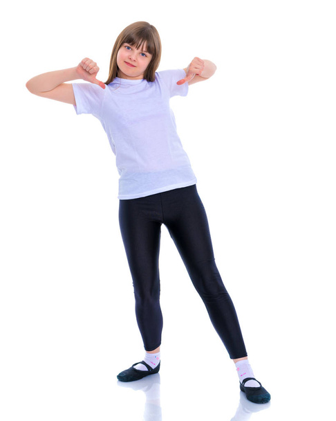 Little school girl pointing to her empty white t-shirt. - Foto, Imagen