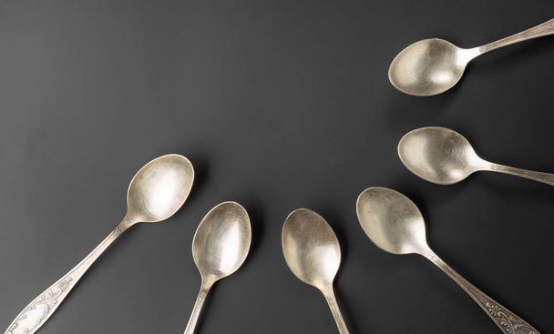 old silver spoons on black background - Φωτογραφία, εικόνα
