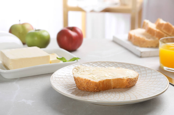 Fresh bread with tasty butter on plate - Foto, Imagen