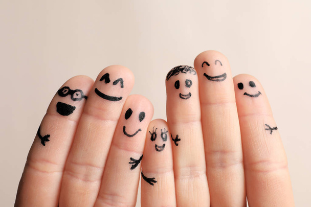 Fingers with drawings of happy faces against light background. Unity concept - Fotó, kép