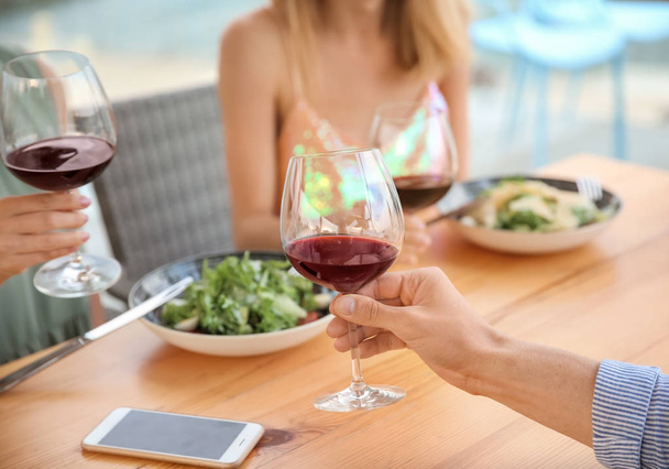 Группа друзей за столом с бокалами вина
 - Фото, изображение