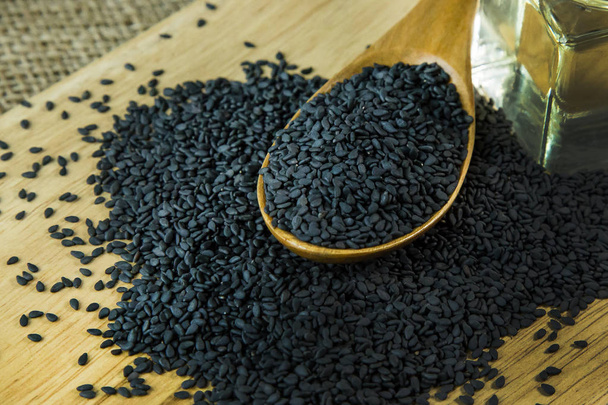 The black Sesame seeds  on a old wooden table. - Photo, Image