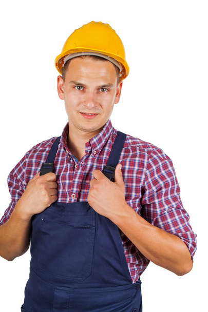 Confident construction worker with yellow hat smiling to the camera on isolated background - Foto, Bild