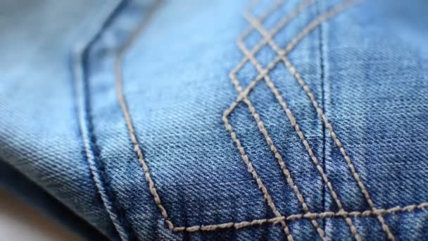 zbliżenie szczegółów niebieskich dżinsów jeansowych, tekstury tła  - Materiał filmowy, wideo