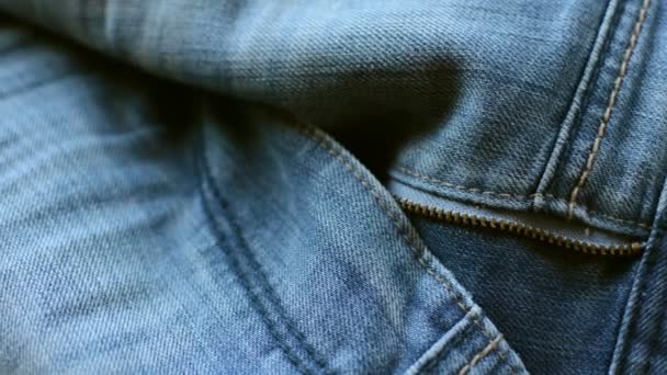 zbliżenie szczegółów niebieskich dżinsów jeansowych, tekstury tła  - Materiał filmowy, wideo