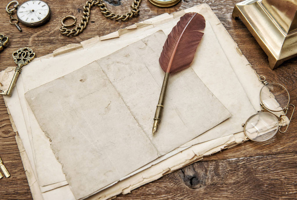 Papel usado vintage com pena caneta. Material de escritório antigo e acessórios em mesa de madeira
 - Foto, Imagem